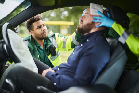 paramedics applying first aid to victim of car crash