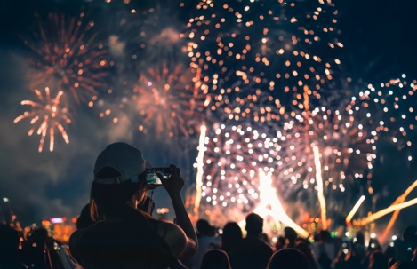 person taking a photo of a fireworks show